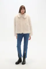 Campera de abrigo color beige claro, con textura de pelo largo y suave, cuello solapa y cierre frontal.