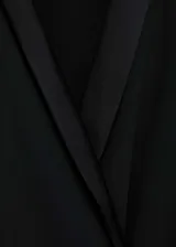 Minivestido negro con escote en V cruzado, mangas largas con puños abotonados, drapeado lateral y cierre cruzado con lazo.