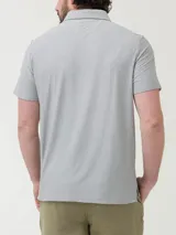 Remera polo azul jaspeado con bolsillo en el pecho y botones en el cuello. Confeccionada con fibras recicladas y spandex con tecnología Natural Flex.