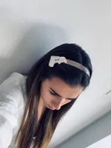 Vincha de estilo minimalista con detalle en nácar, ideal para complementar tu look.