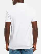 Chomba blanca de piqué de algodón elástico, con cuello clásico, tapeta de dos botones y monograma bordado de Calvin Klein en el pecho.