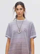 Vestido corto de tejido calado con cuello redondo y mangas cortas con puños a rayas en color contrastante. Diseño degradado en tonos lila y borgoña.