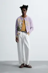 Cárdigan lila con diseño floral, cuello redondo, manga larga, rib en puños y ruedo, y cierre frontal con botones.