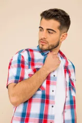 Camisa de manga corta con estampado a cuadros en tonos azul, rojo y blanco. Cierre con botones y tela ligera.
