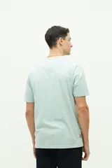Remera de manga corta color verde agua con estampado de texto en el frente.