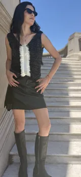 Musculosa tejida en látex metálico color negro, con escote en V en frente y espalda y detalle de flecos en el frente.