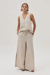 Top sin mangas color beige claro, con escote en V, confeccionado en lino.