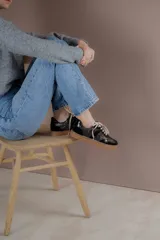 Championes acordonados color beige y dorado con suela marrón.