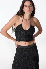 Top negro con lurex plateado, escote halter y espalda descubierta.