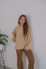 Buzo color beige de viscosa, con cuello redondo y mangas largas abullonadas.
