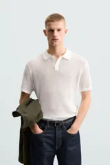 Polo blanco de punto tejido con estructura calada, corte regular fit, cuello solapa con abertura frontal y manga corta.