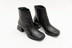 Botas cortas de cuero plateado y negro con punta cuadrada y taco geométrico.