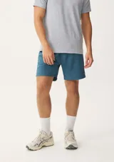 Short deportivo azul con cintura elástica y logo pequeño en la pierna.