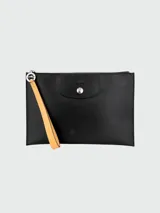Estuche Longchamp Le Pliage negro con cierre superior y correa de muñeca color caramelo.