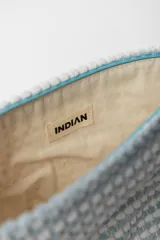 Neceser rojo con textura de tejido de toalla y cierre superior con cremallera.