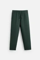 Pantalón largo verde oscuro de algodón con textura, corte recto y cintura elástica ajustable con cordón.