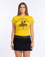Remera roja de manga corta y calce ajustado (baby tee) con cuello redondo. Presenta un estampado frontal en celeste que incluye el texto "DELOALTO CLUB", una figura femenina con cola de sirena montando a caballo, una palmera y el texto "Deloalto mvdeo est. 2015".