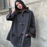 Saco tipo capa color gris de tejido de punto fino en lana con detalles de cintas tejidas y trenza.