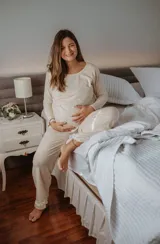 Pijama largo de algodón color beige, apto para embarazo y lactancia. La remera de manga larga cuenta con apertura para amamantar y detalles de puntilla elastizada. El pantalón cuenta con elástico ajustable y detalles de puntilla elastizada.
