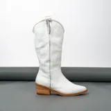 Bota texana de cuero vacuno negro con detalles bordados en dorado y plateado en la caña. Tiene taco de madera con folia de cuero de 5cm, entre suela de goma de 1cm, inclinación de horma de 4cm, altura de caña de 31cm y cierre YKK del lado interno. La horma es de punta fina, ancha y cómoda.
