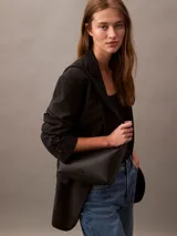 Bandolera negra de Calvin Klein con correa ancha con el logo de la marca.