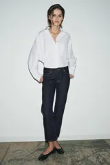 Jeans de tiro medio color beige, corte cigarette, con cinco bolsillos y cierre frontal de cremallera y botón.