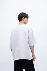 Remera color gris claro, de algodón lavado con textura extra suave, calce boxy y bolsillo en el pecho.