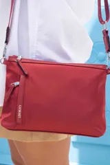 Bandolera negra de nylon con correa de galón a tono, cierre superior y bolsillos frontal y trasero con cierre.