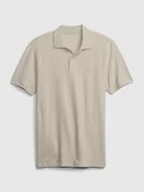 Remera tipo polo color beige claro, de manga corta, con cuello clásico y logo bordado en el pecho.