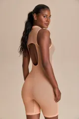 Enterito corto color salmón, de tejido de punto sin costuras, con cierre frontal y espalda descubierta.