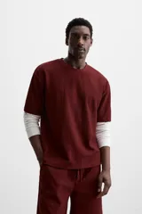 Camiseta negra de corte holgado, con cuello redondo y mangas cortas.