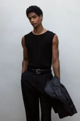 Musculosa negra de punto acanalado, con corte ajustado y ribete acanalado fino en escote, sisas y bajo.