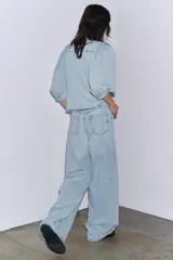 Blusa de denim celeste con cuello solapa y mangas abullonadas por debajo del codo. Cierre frontal con botones.