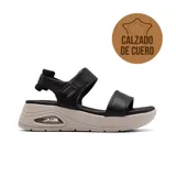 Sandalia de cuero negra con plataforma beige y ajuste con velcro.