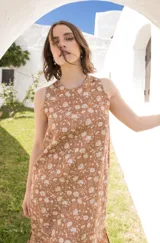 Vestido midi sin mangas con estampado floral, tajos laterales y cierre con botón en la espalda.