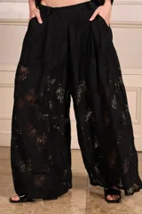 Pantalón palazzo negro de encaje con forro tipo short, pinzas, bolsillos y elástico en la cintura trasera.