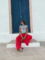 Blusa sin mangas a rayas verticales blancas y verdes, con cuello alto fruncido y volados decorativos en escote y hombros, con terminaciones en rojo.