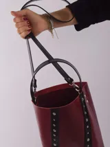 Bolso matero color bordó, de cuero, con doble asa (una de mano y otra larga desmontable), divisor interno para termo y mate, y bolsillo interior.