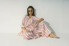 Camisa a rayas verticales blancas y negras, de corte recto y mangas largas.