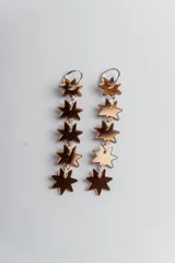 Par de aros colgantes con aro de acero quirúrgico y estrellas de acrílico doradas.