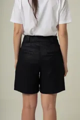 Bermuda color beige de tiro alto, con bolsillos laterales y trabillas para cinturón.