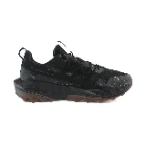 Championes negros de trail running New Balance, con suela marrón y detalles en gris.