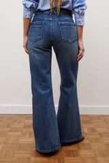 Jean de corte semi oxford con tiro alto, confeccionado en denim azul oscuro con costuras a la vista y bolsillos funcionales.