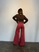 Pantalón jean fucsia de tiro medio, corte wide leg con godets y ruedo desflecado.
