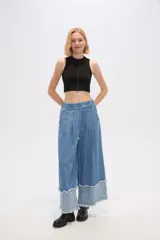 Pantalón de jean azul de corte ancho y tiro alto, con bolsillos y pinzas.