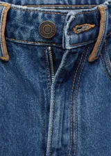 Pantalón de jean azul de corte recto, tiro medio, con cierre de cremallera y botón, cinco bolsillos y detalle en contraste.