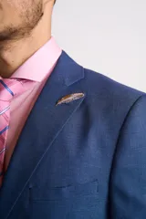 Traje azul de corte clásico, compuesto por saco de dos botones con solapa de muesca y pantalón de vestir con pinzas.