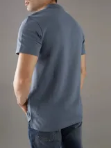 Chomba de piqué azul con cuello polo y tapeta de tres botones. Tiene mangas cortas, corte relaxed y logo de Calvin Klein bordado en el pecho. Confeccionada en algodón.