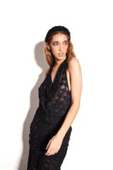 Top negro de encaje con cuello halter y corte fluido en el pecho.