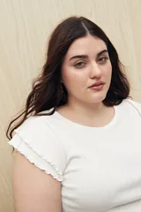 Top color rosado de tejido de punto acanalado, con cuello redondo y mangas cortas con volados.